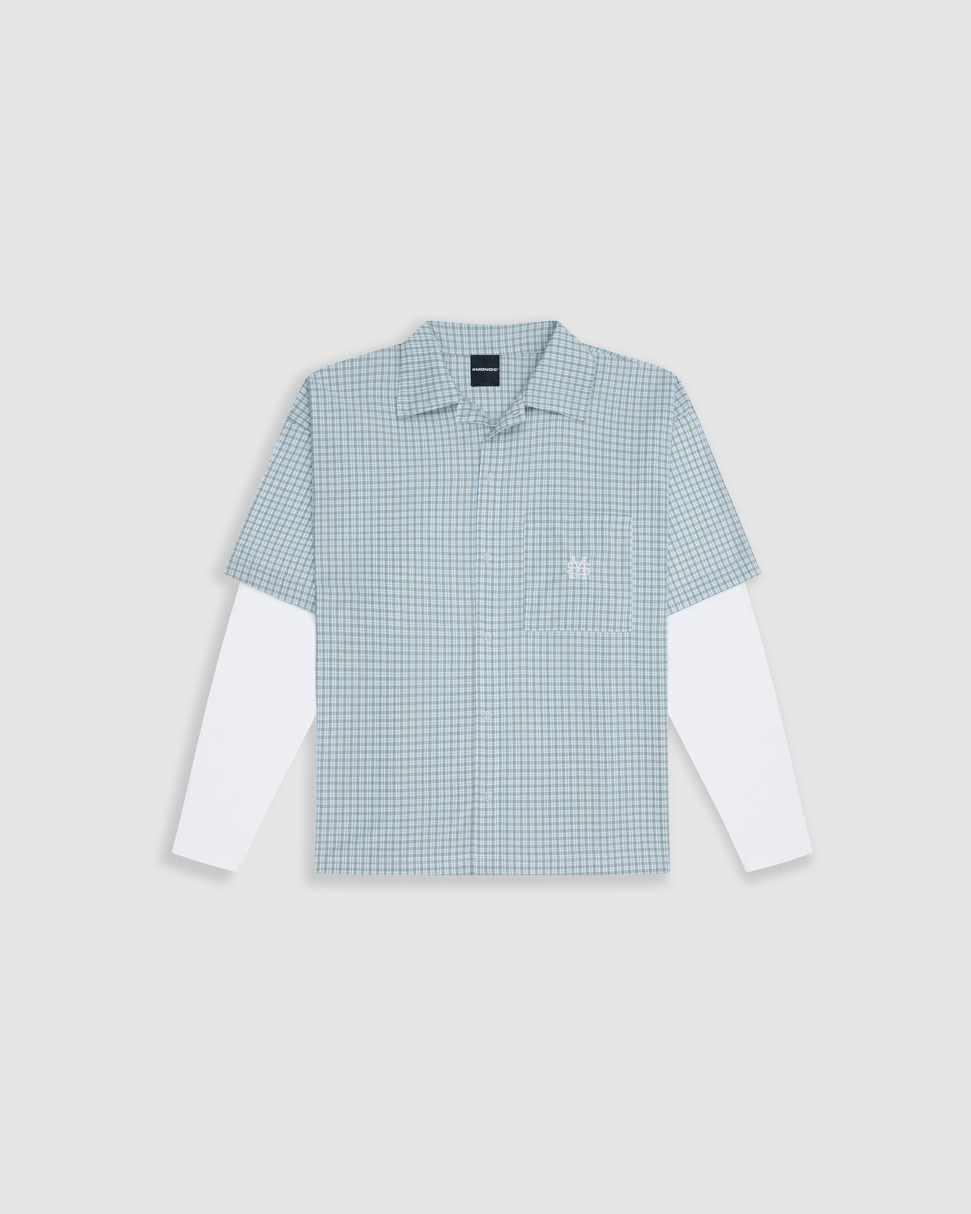 Checkered double sleeve shirt with light green, blue, and white plaid body, off-white contrast sleeves, boxy fit, and embroidered monogram on the chest pocket.