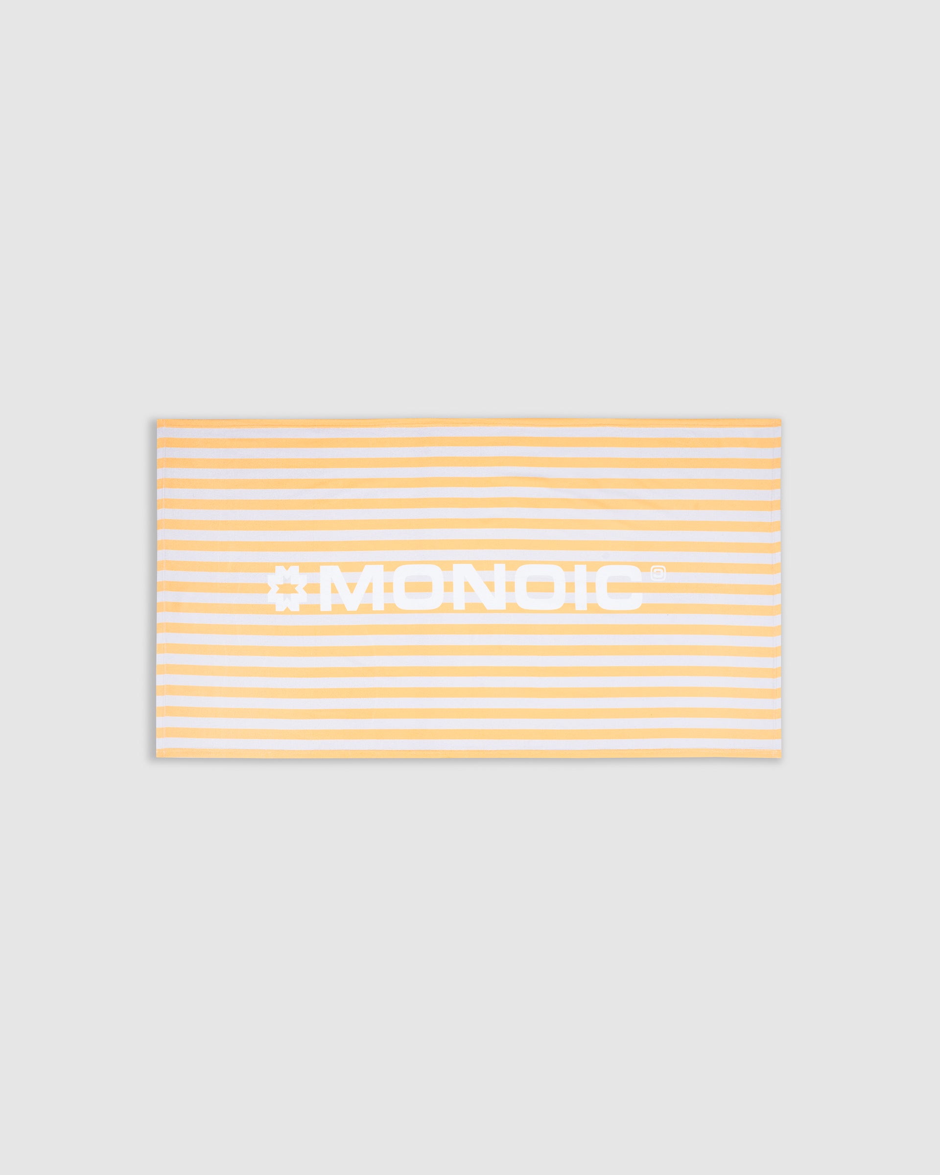 Monoic cotton towel with white background, bold yellow stripes, and “Monoic” written horizontally.