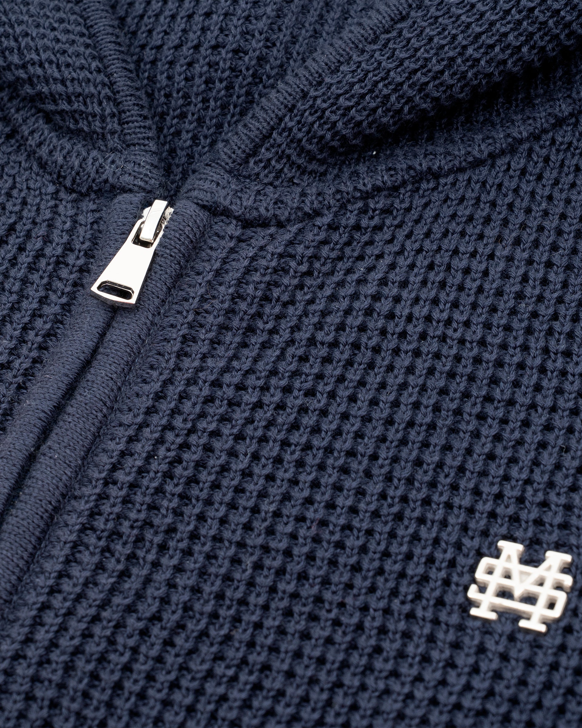 Zip Knitwear Hoodie in Navy Blue with metallic monogram, kangaroo pocket, and double zipper.